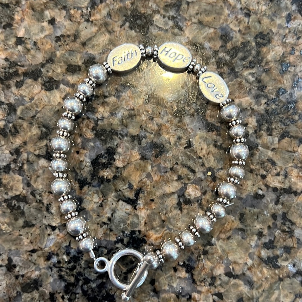7 3/4 inch long silver bracelet with faith, hope, love as the centerpiece
